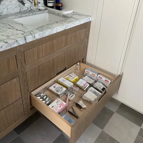 Bathroom drawer organization in Britannia, Calgary, featuring boutique-style skincare and makeup storage for a simplified morning routine.