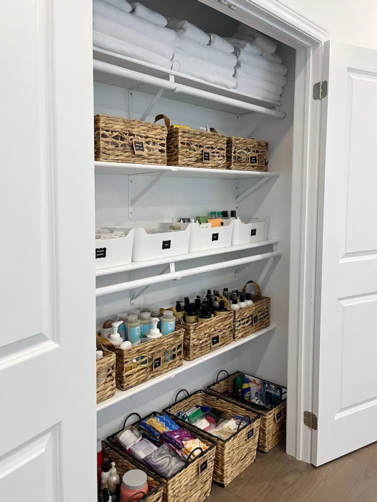 Linen closet bathroom overflow storage in Elbow Park, showcasing sustainable wicker basket systems and intuitive bathroom organization by Well Arranged Home